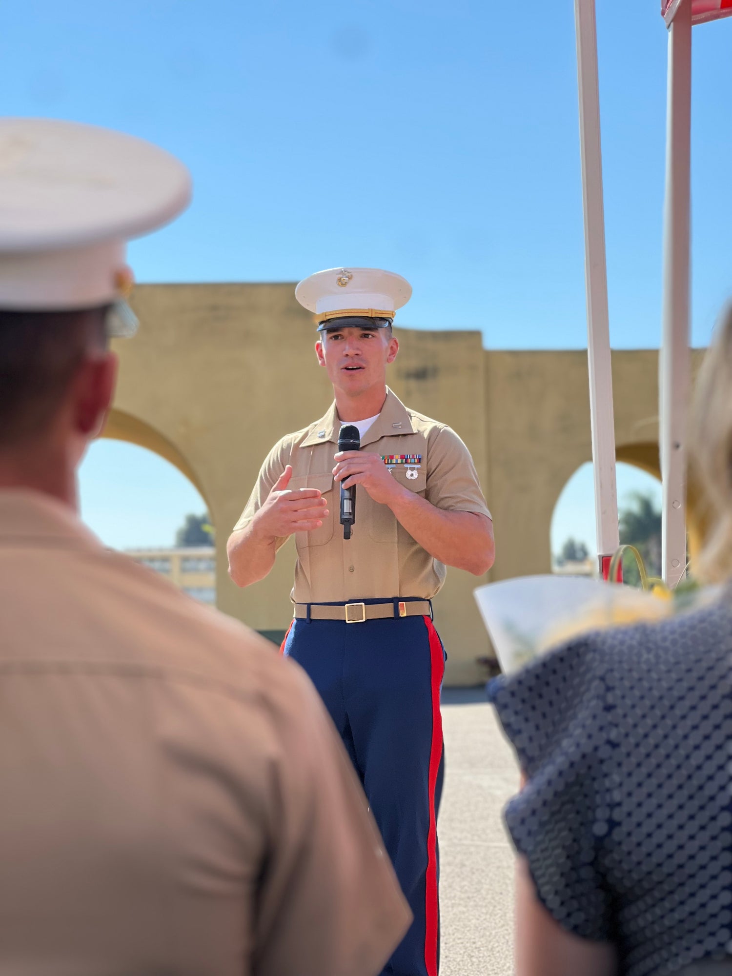 Marine Corps officer speaking at outdoor ceremony, representing leadership and resilience within the Restless community