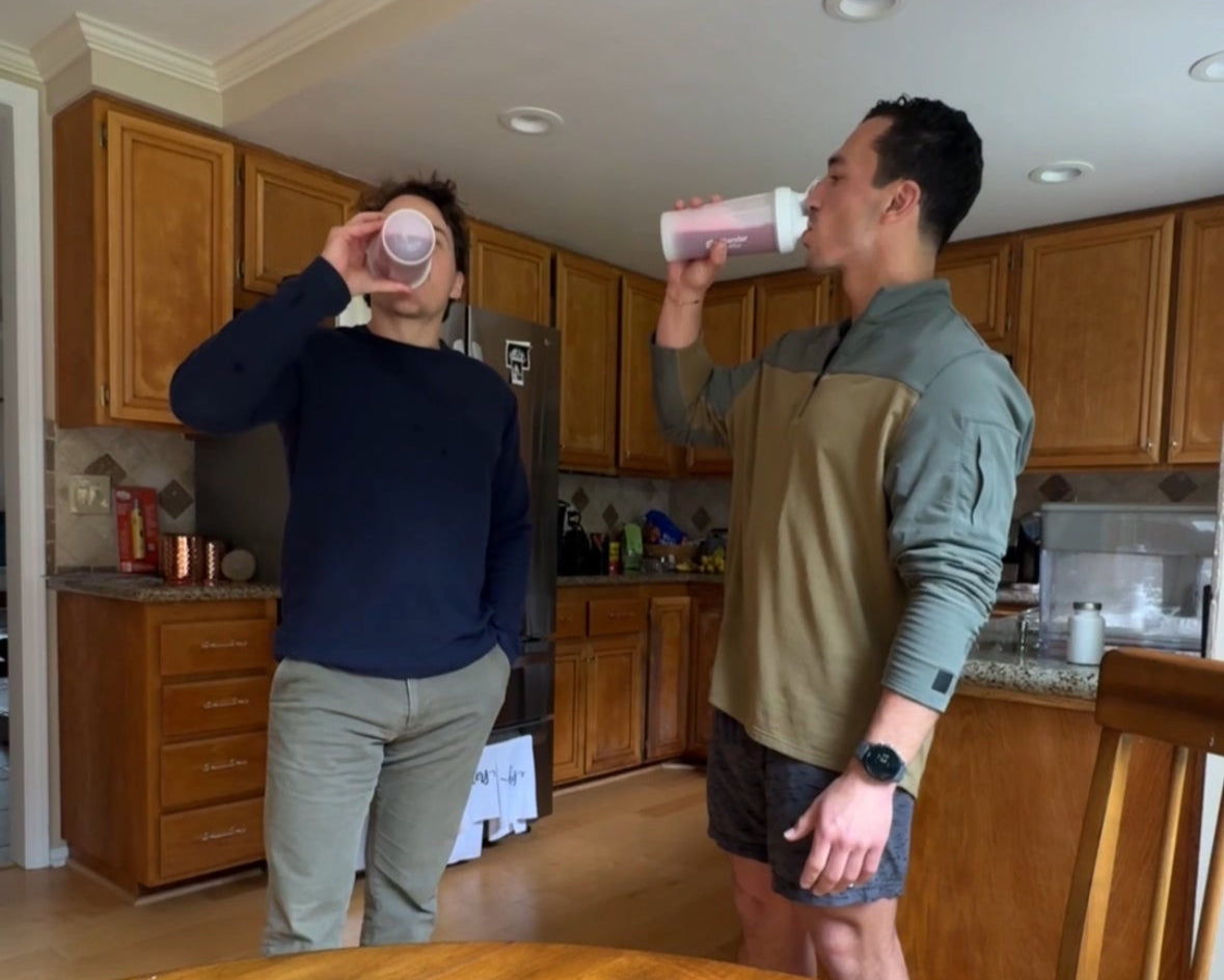 Two men drinking Restless clean energy drink in kitchen after workout and sampling how it quenches you.